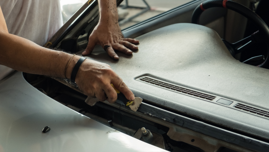 persona limpiando un parabrisas para poder poner un cristal nuevo