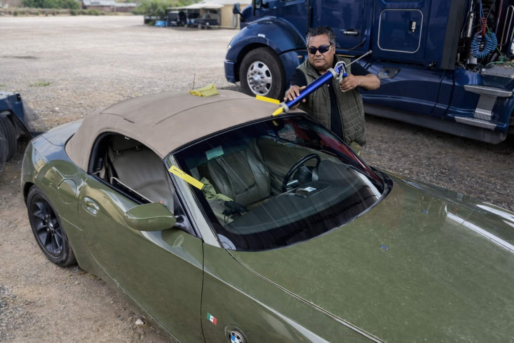 persona cambiando parabrisas a carro verde a domicilio en tijuana